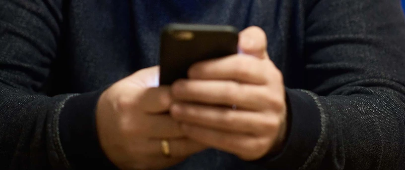 Hænder holder en mobiltelefon