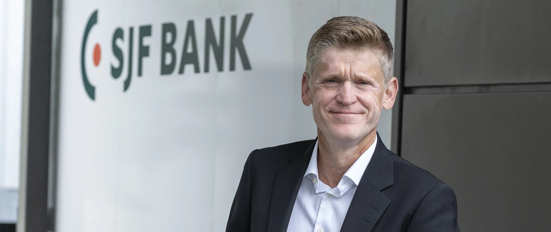 Jes Asmussen foran SJF Banks logo