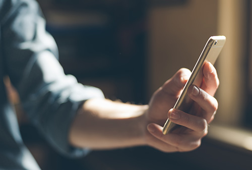 Hånd der holder en mobiltelefon